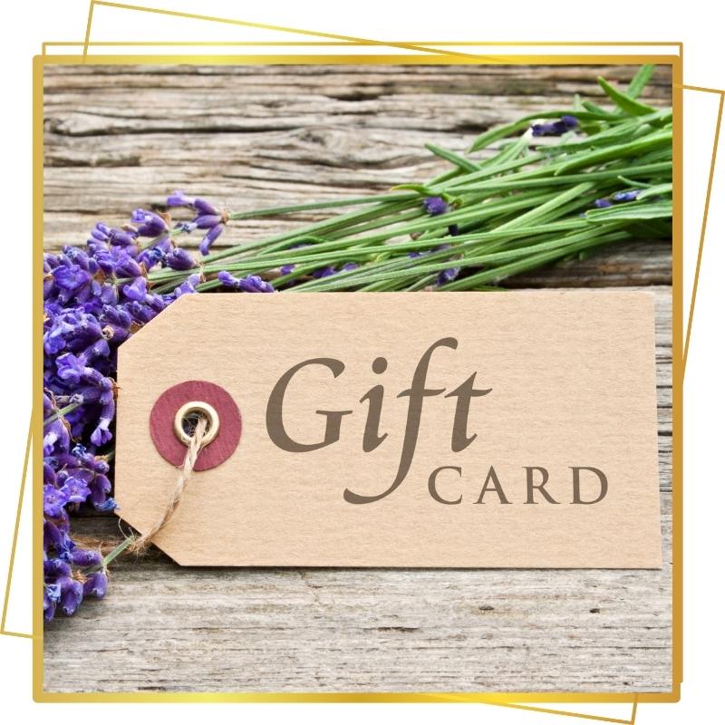 A gift card lying on a rustic wooden surface with sprigs of lavender and rosemary.